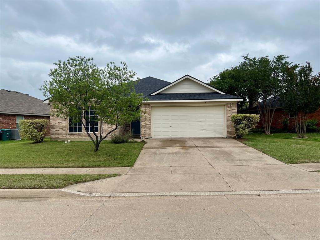 12201 Rolling Ridge Drive Fort Worth, TX 76028 - Photo 2 of 21 Single-story brick residence featuring a two-car garage, a dark asphalt shingle roof, and a mature tree in the front yard
