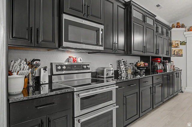 3034 Swiss Drive Santa Clara, UT 84765 - Photo 21 of 59 Kitchen featuring abundant dark-finish cabinetry, stainless steel appliances, a built-in microwave, and stone countertops