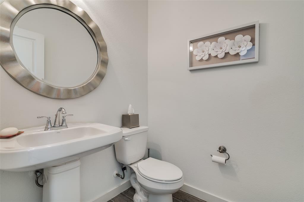 2724 Splendor Lane Little Elm, TX 75068 - Photo 12 of 25 a bathroom with a toilet a sink and a mirror