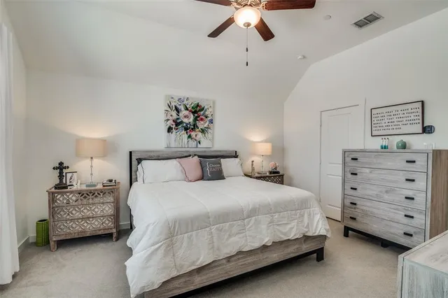 a bedroom with a bed a flat screen tv and a window