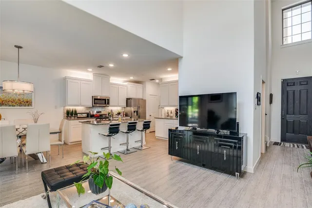 a living room with furniture a flat screen tv and kitchen view
