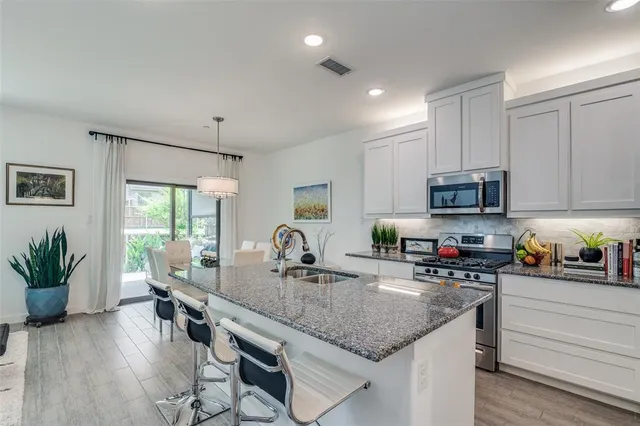 a kitchen with sink a microwave and cabinets