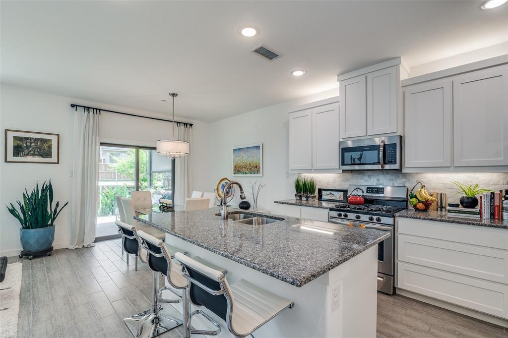 2724 Splendor Lane Little Elm, TX 75068 - Photo 8 of 25 a kitchen with sink a microwave and cabinets