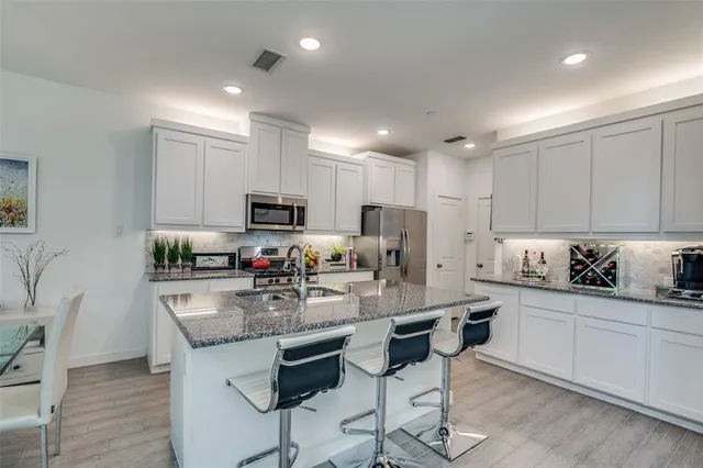 a kitchen with kitchen island granite countertop a sink and cabinets