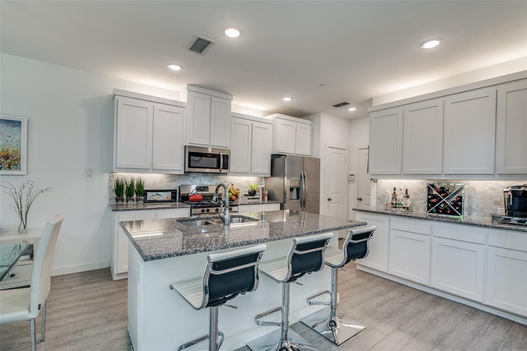 2724 Splendor Lane Little Elm, TX 75068 - Photo 9 of 25 a kitchen with kitchen island granite countertop a sink and cabinets
