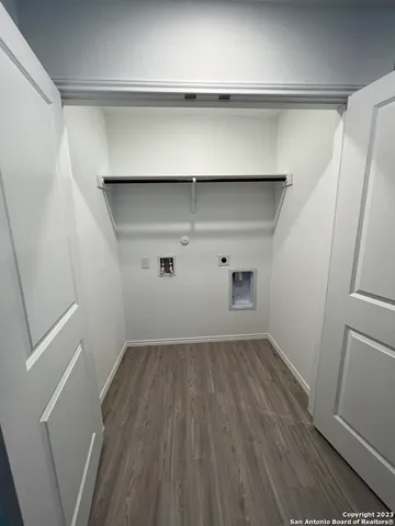 a view of storage and utility room with wooden floor