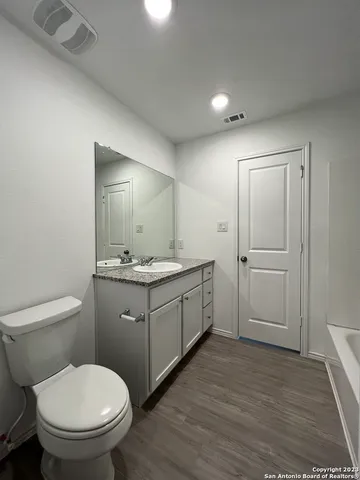 a bathroom with a toilet sink and mirror