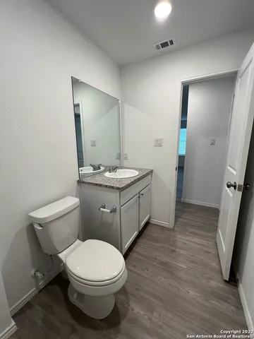 a bathroom with a toilet a sink and mirror