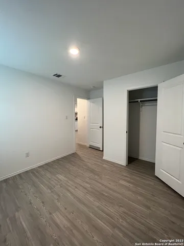 an empty room with wooden floor and white doors