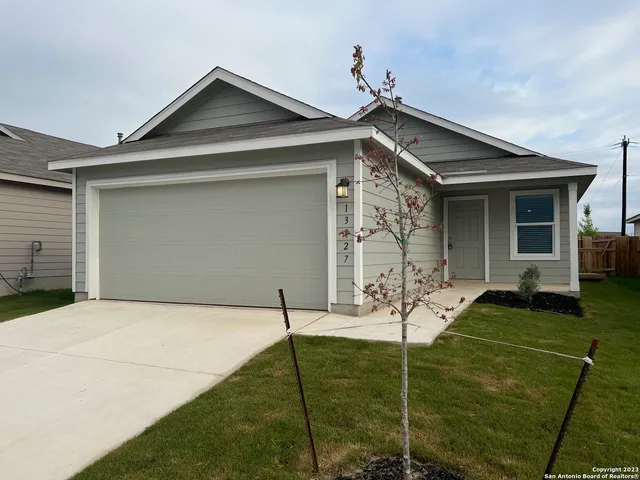 a backyard of a house with table and chairs