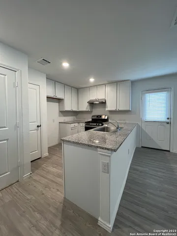 a kitchen with granite countertop a sink and a refrigerator