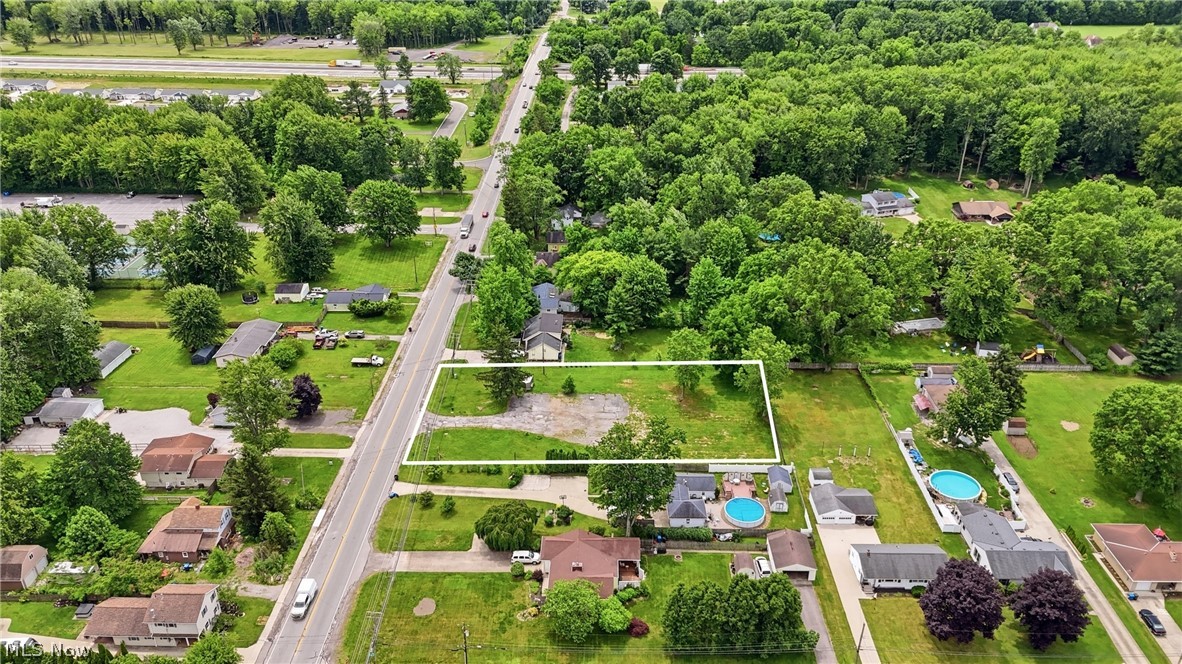 7474 Avon Belden Road North Ridgeville, OH 44039 - Photo 4 of 6 Expansive cleared lot outlined with a white border, featuring mature trees and a grassy area