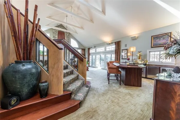 a living room with couches and a dining table with wooden floor