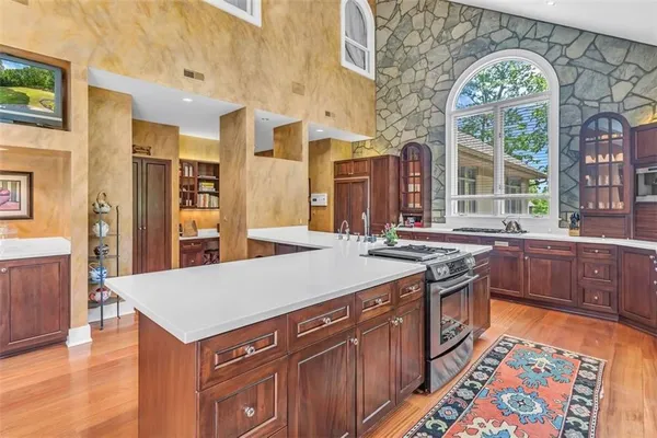 a kitchen with stainless steel appliances granite countertop a stove and a wooden cabinets