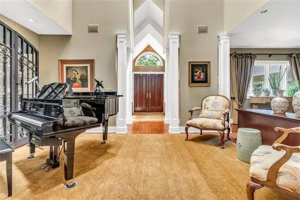 a living room with furniture a piano and wooden floor
