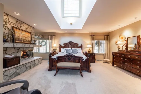a spacious bedroom with a bed couch and dresser