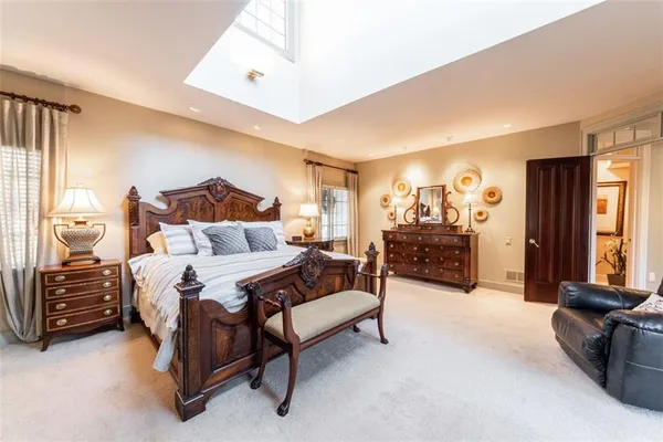 a spacious bedroom with a bed couch and a window