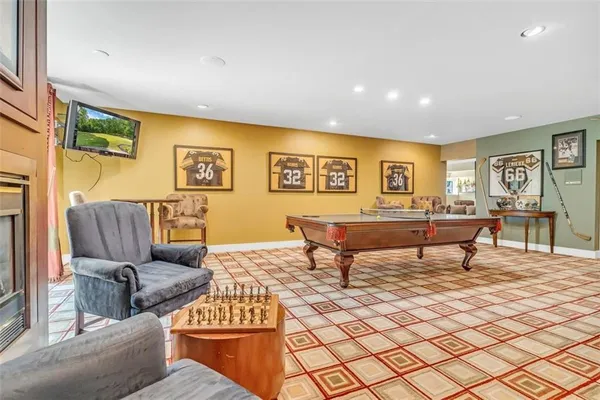 a living room with furniture a flat screen tv and kitchen view