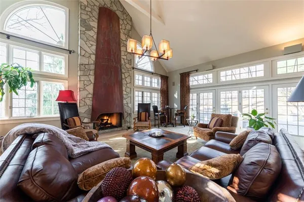 a living room with furniture a chandelier and a large window
