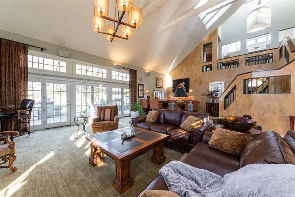 a living room with furniture a large window and chandelier