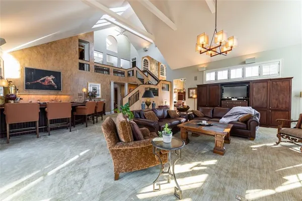 a living room with furniture a chandelier and a flat screen tv