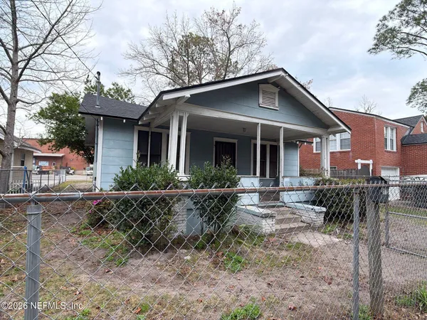 a view of a house with yard and chairs in patio