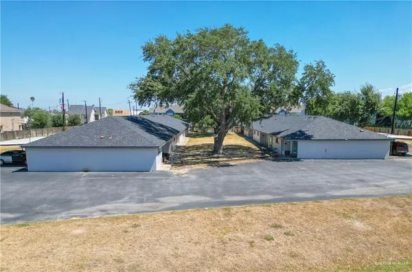 a view of a house with a yard and large tree