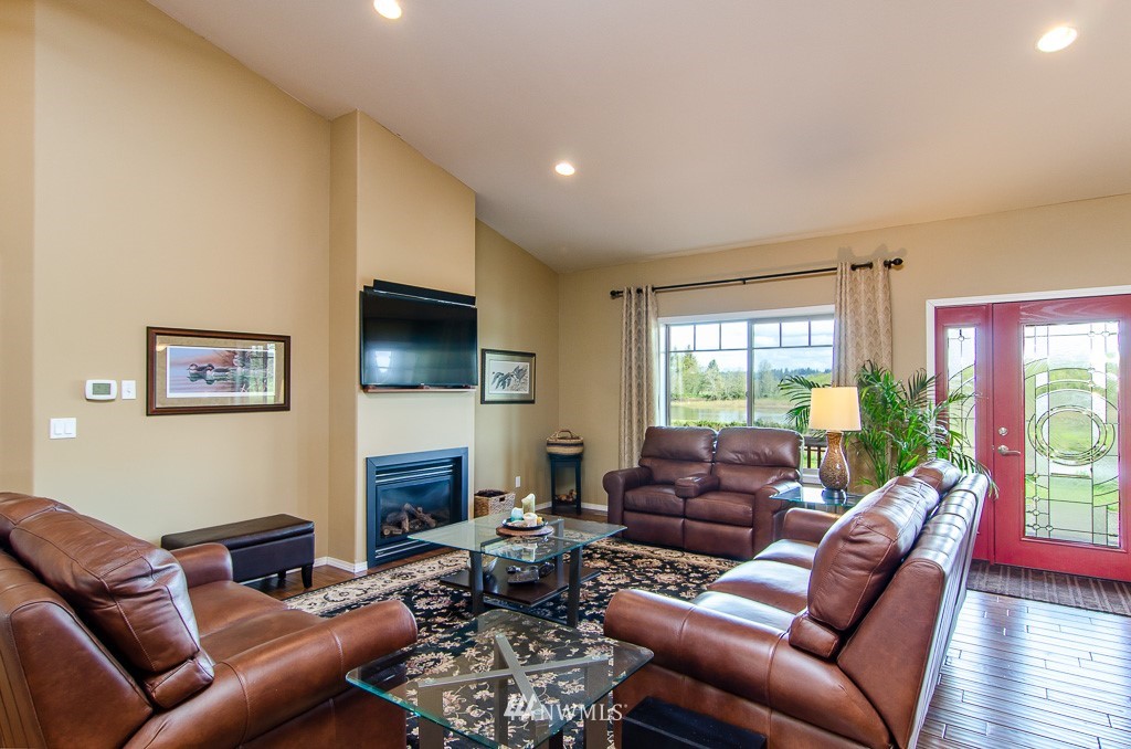 15 South Bank Road Elma, WA 98541 - Photo 7 of 32 a living room with furniture a flat screen tv and a fireplace