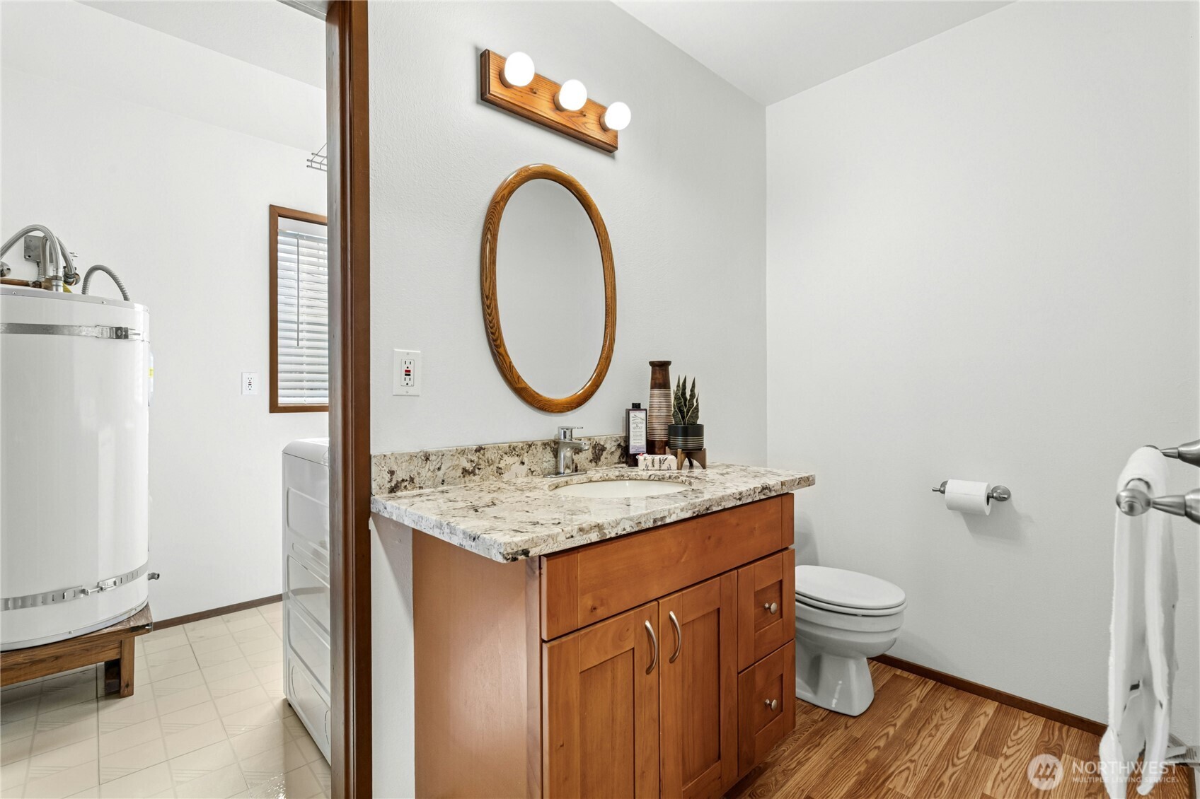 5211 103rd Street Southwest, Unit SW Mukilteo, WA 98275 - Photo 29 of 40 a bathroom with a granite countertop toilet a sink and a mirror