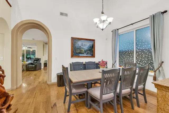 a kitchen with stainless steel appliances granite countertop a stove a sink dishwasher and a refrigerator with wooden floor