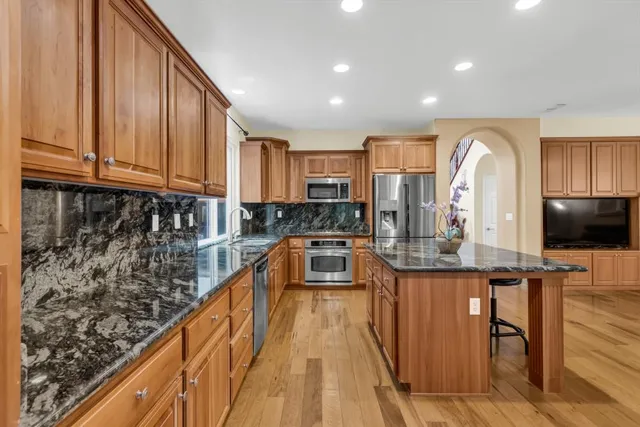 a living room with stainless steel appliances furniture or kitchen view and a fireplace