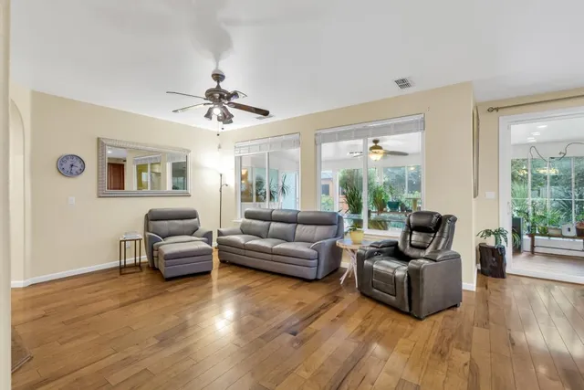 a bedroom with a bed a mirror on dresser and a wooden floor