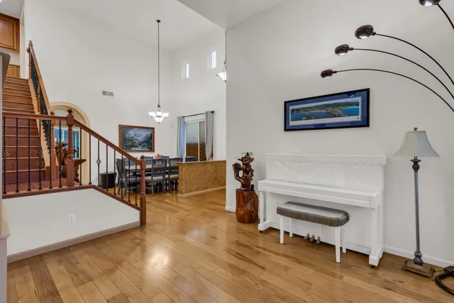 a dining room with furniture a chandelier and wooden floor