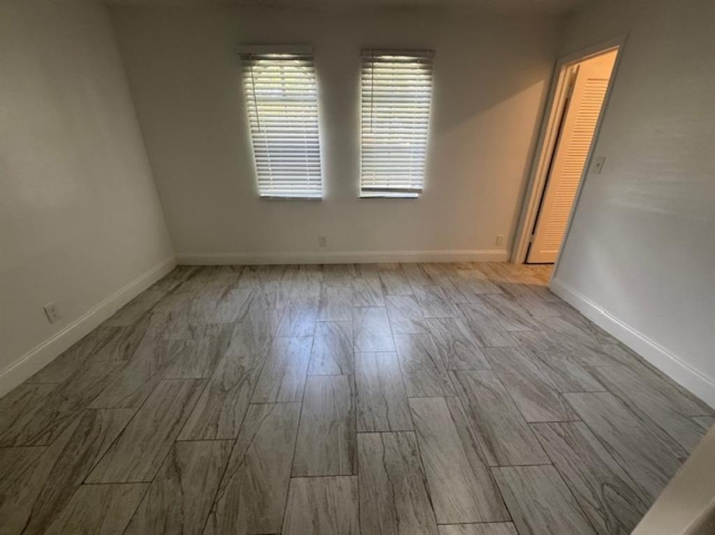 481 Banks Road, Unit 1 Margate, FL 33063 - Photo 11 of 13 an empty room with wooden floor and windows
