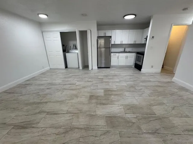 a view of a refrigerator in kitchen and a window
