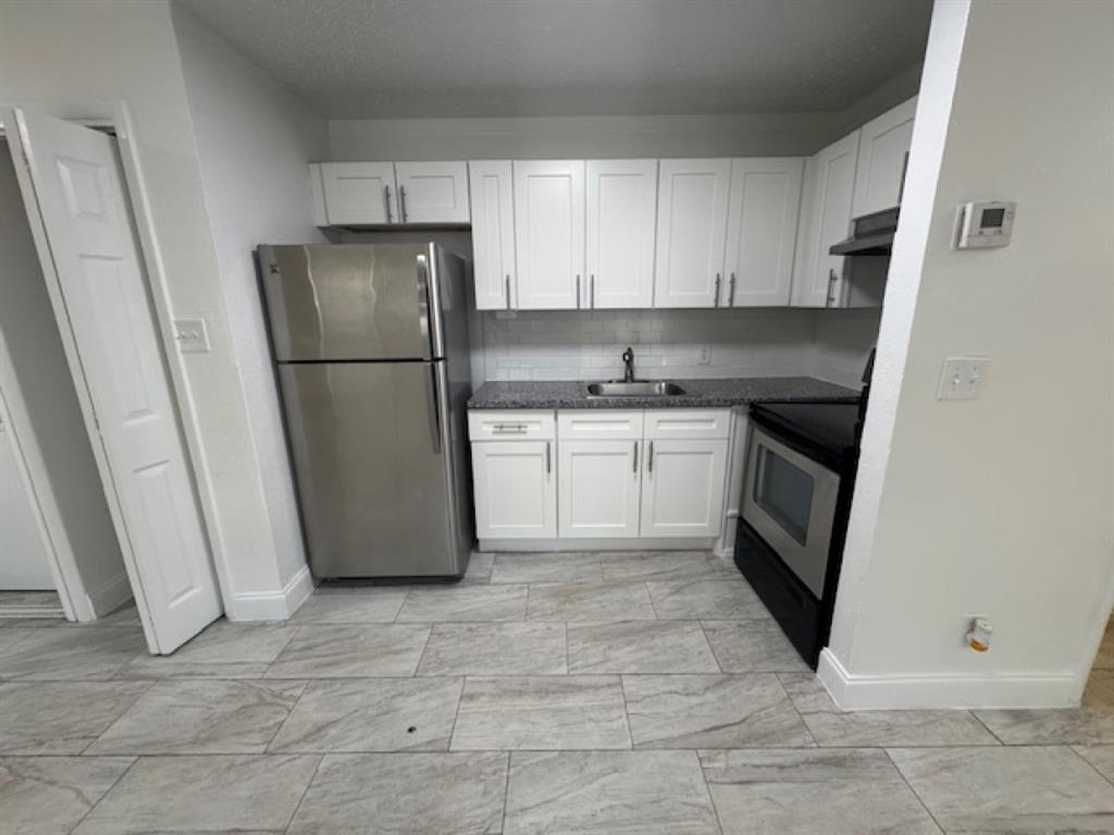 481 Banks Road, Unit 1 Margate, FL 33063 - Photo 7 of 13 a kitchen with a refrigerator sink and cabinets