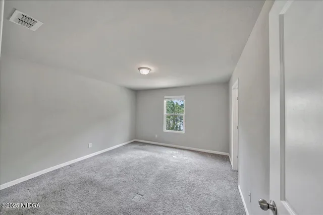 an empty room with windows and closet