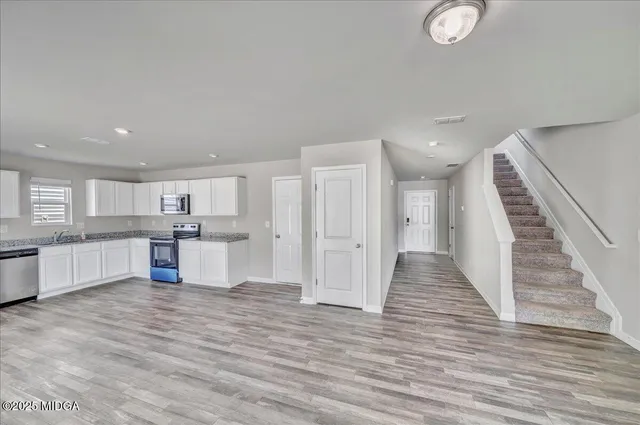 a kitchen with granite countertop a stove top oven and cabinets