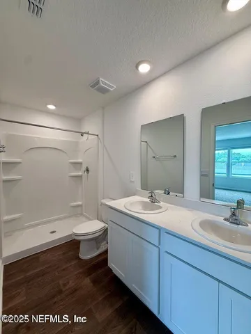 a bathroom with a sink a toilet and shower