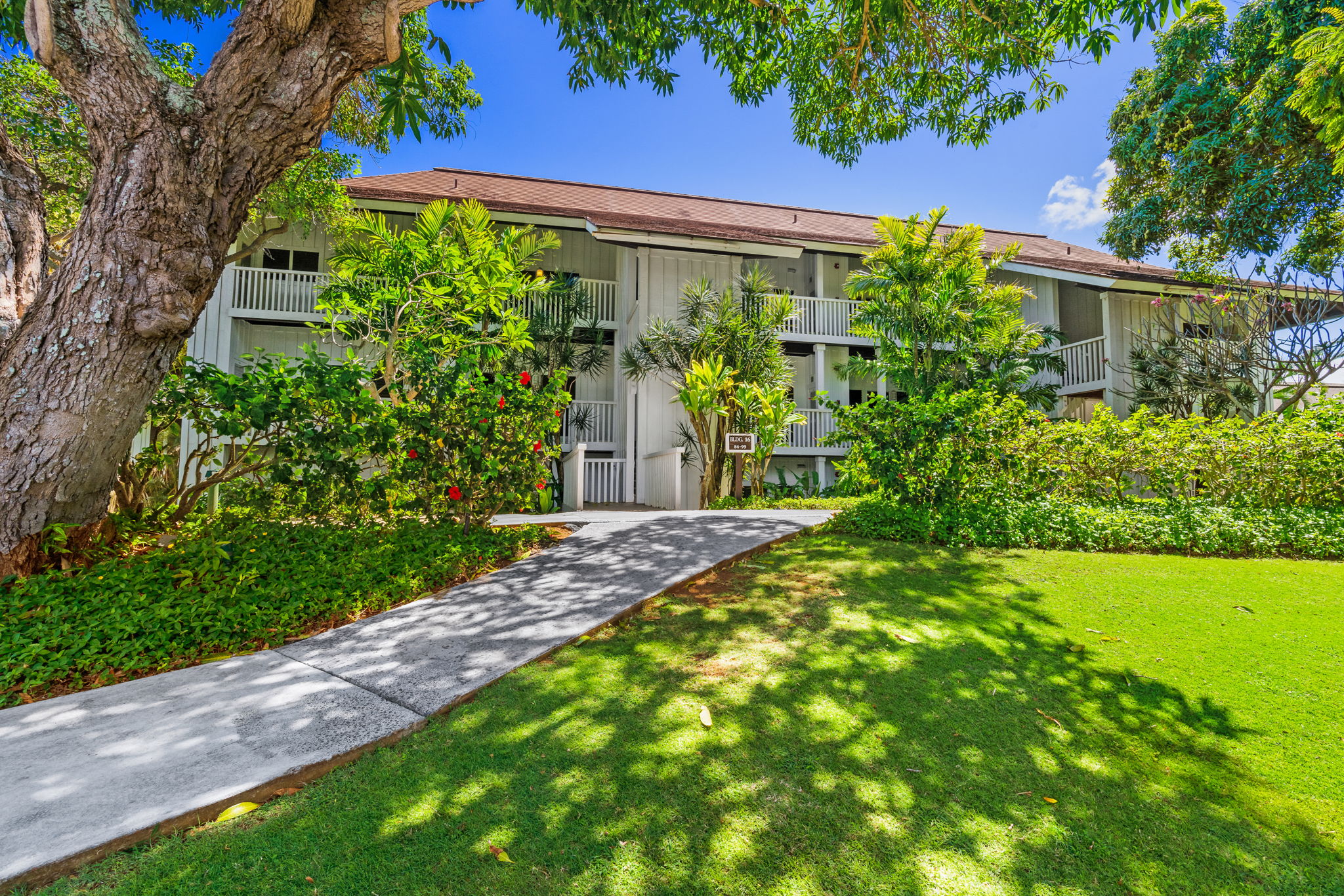 2253 Poipu Road, Unit 99 Koloa, HI 96756 - Photo 24 of 30 a view of a garden with plants and a bench