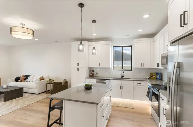 a kitchen with stainless steel appliances granite countertop a sink refrigerator and cabinets