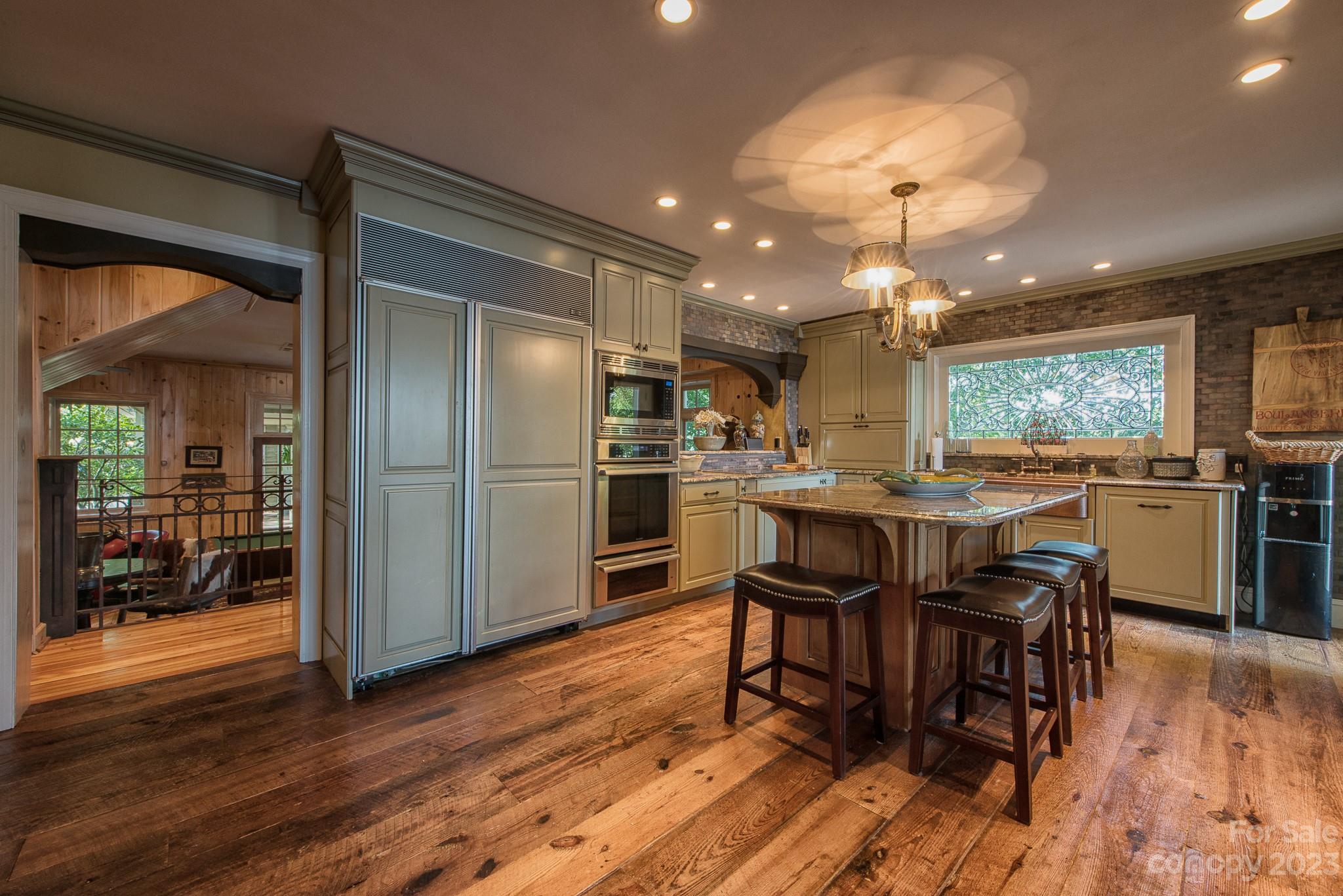 135 Winston Way Troutman, NC 28166 - Photo 25 of 48 a kitchen with stainless steel appliances granite countertop a refrigerator a stove a sink a dining table and chairs with wooden floor