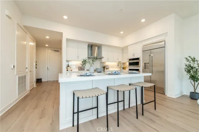 a kitchen with stainless steel appliances granite countertop a refrigerator and a stove top oven