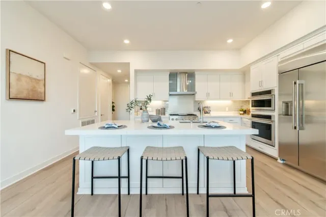 a kitchen with kitchen island granite countertop a sink and stainless steel appliances