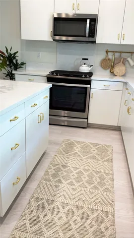a kitchen with stainless steel appliances granite countertop a sink and a stove