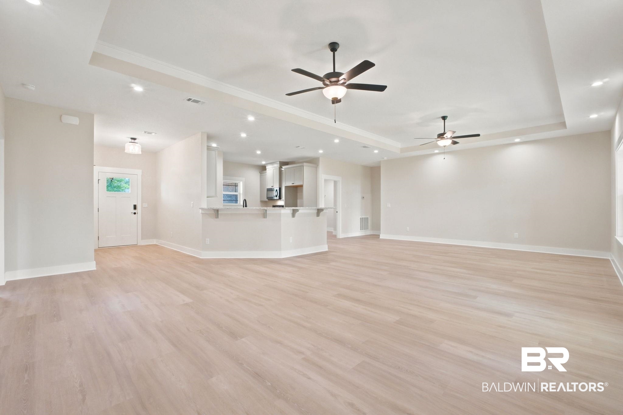 32656 Arbor Ridge Circle Lillian, AL 36549 - Photo 3 of 56 Open-concept living space featuring wood-finish flooring, recessed lighting, ceiling fans, tray ceilings, and a breakfast bar