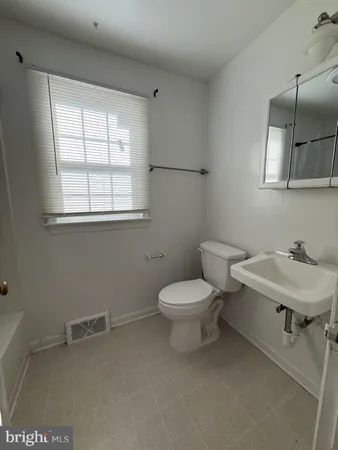 a bathroom with a toilet a sink and mirror