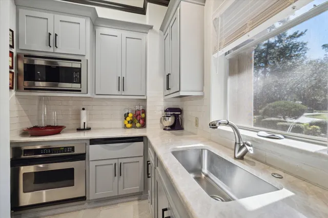 a kitchen with stainless steel appliances granite countertop a sink and a stove