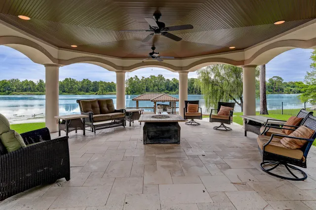 a living room with patio furniture and a floor to ceiling window
