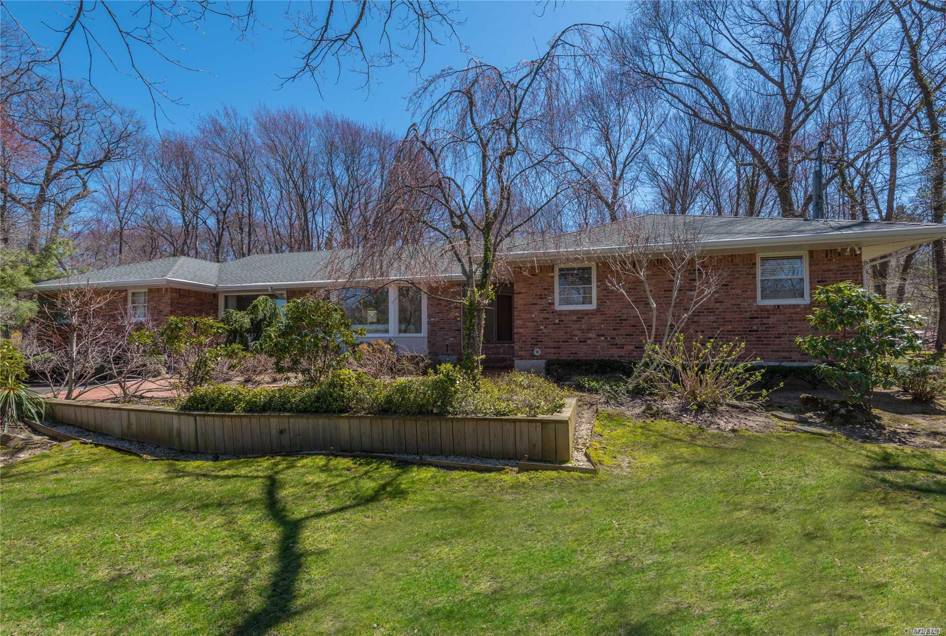 a front view of a house with a yard and potted plants